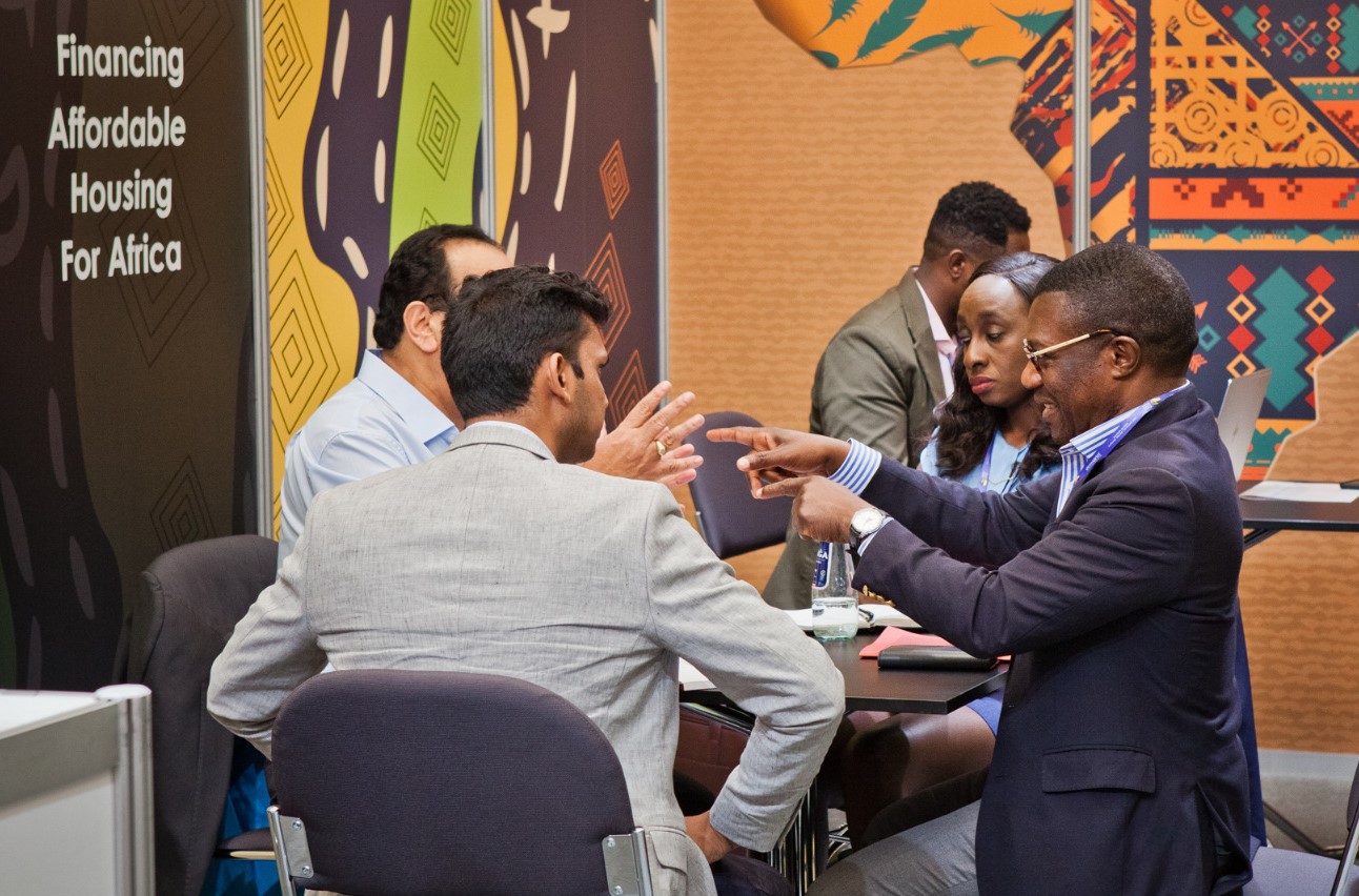 Shelter Afrique Ag. CEO & Chief Finance Officer Mr. Kingsley Muwowo (right) explaining engaging with delegates at the 11th World Urban Forum held in the Polish city of Katowice.